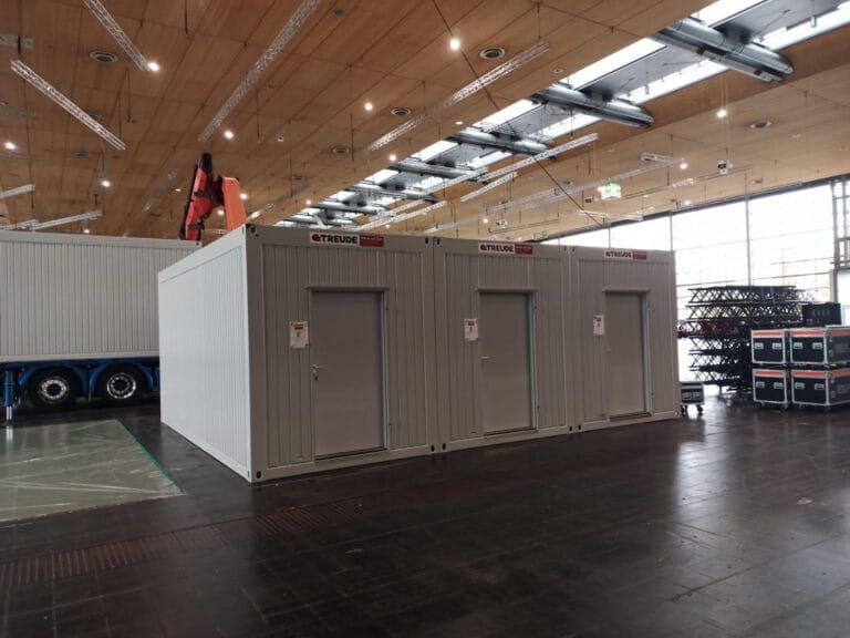 grauer ausstellungscontainer in einer messehalle