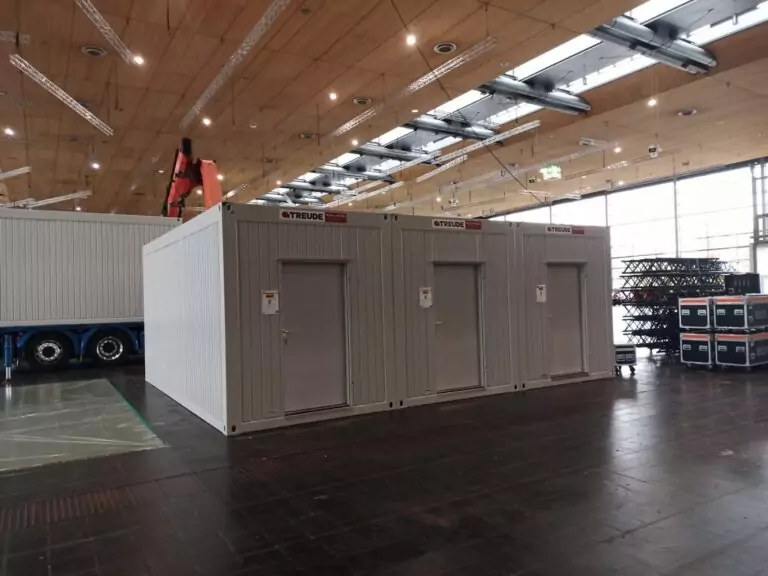 grauer ausstellungscontainer in einer messehalle