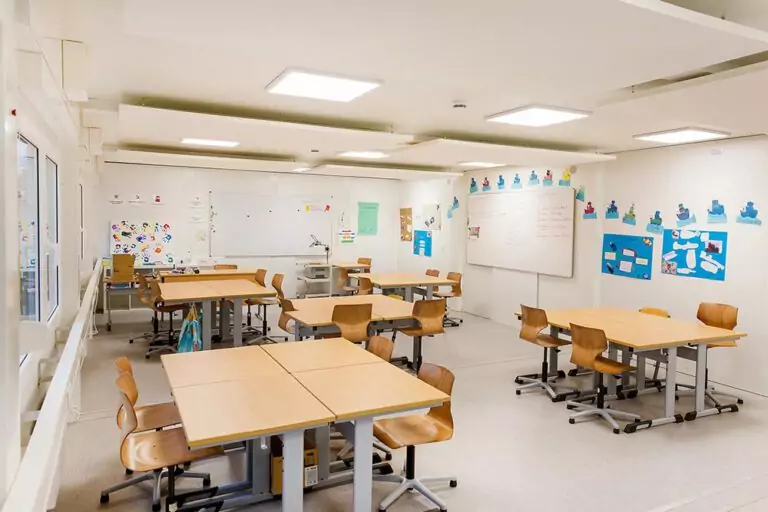 Klassenraum im Schulcontainer mit Tischen und Stühlen