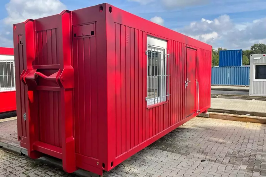 Roter Abrollcontainer mit vergittertem Fenster und Tür